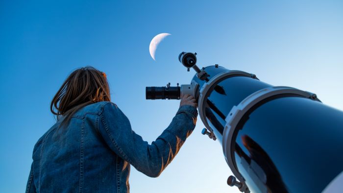 Astronomer looking at moon with telescope